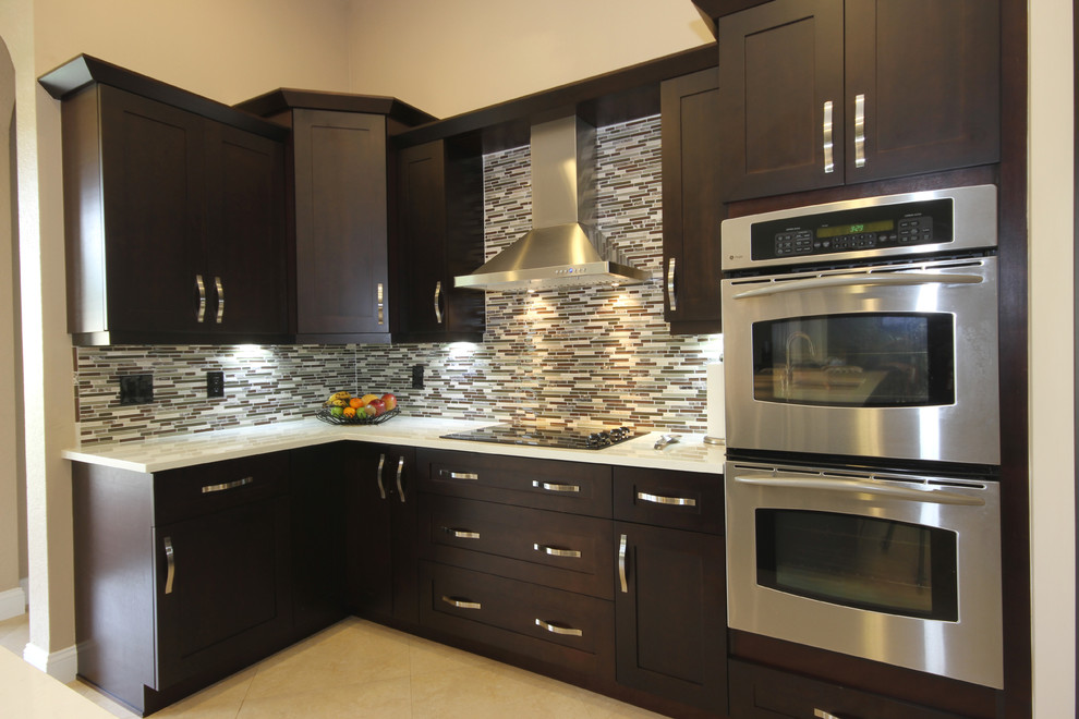 Photo of a modern l-shaped eat-in kitchen in Miami with an undermount sink, shaker cabinets, dark wood cabinets, quartzite benchtops, multi-coloured splashback and stainless steel appliances.