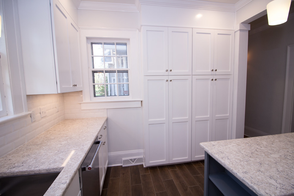 Small u-shaped ceramic tile eat-in kitchen photo with an undermount sink, shaker cabinets, white cabinets, quartz countertops, white backsplash, subway tile backsplash, stainless steel appliances, an island and white countertops