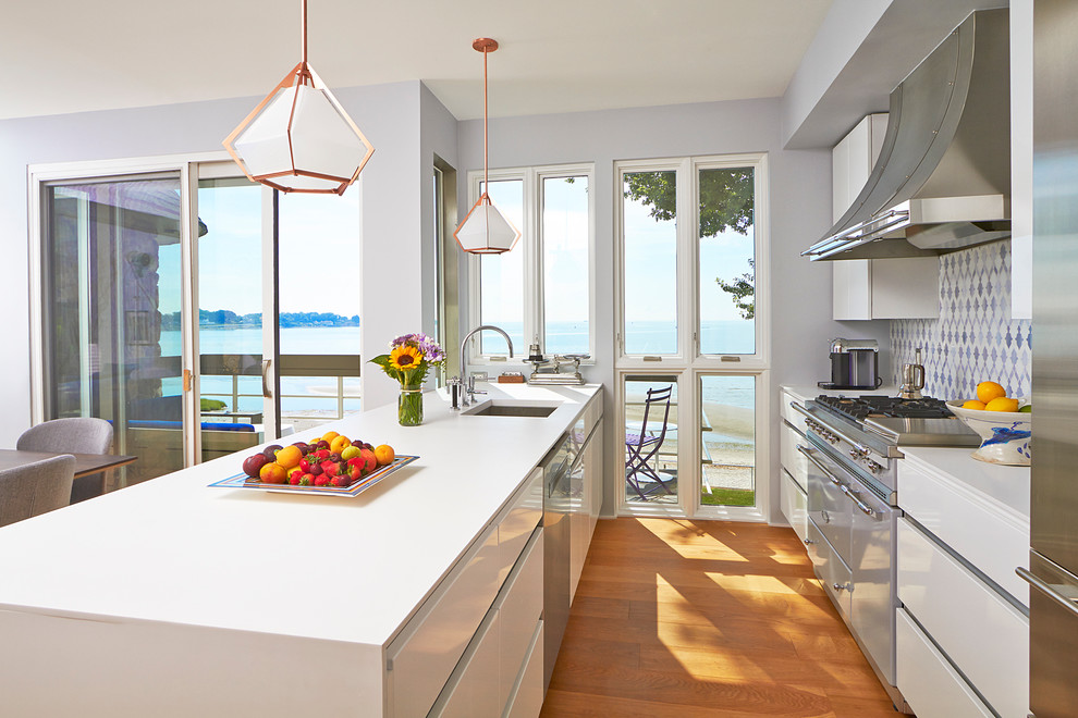 Design ideas for a contemporary galley open plan kitchen in New York with an undermount sink, flat-panel cabinets, white cabinets, quartz benchtops, multi-coloured splashback, stainless steel appliances and a peninsula.