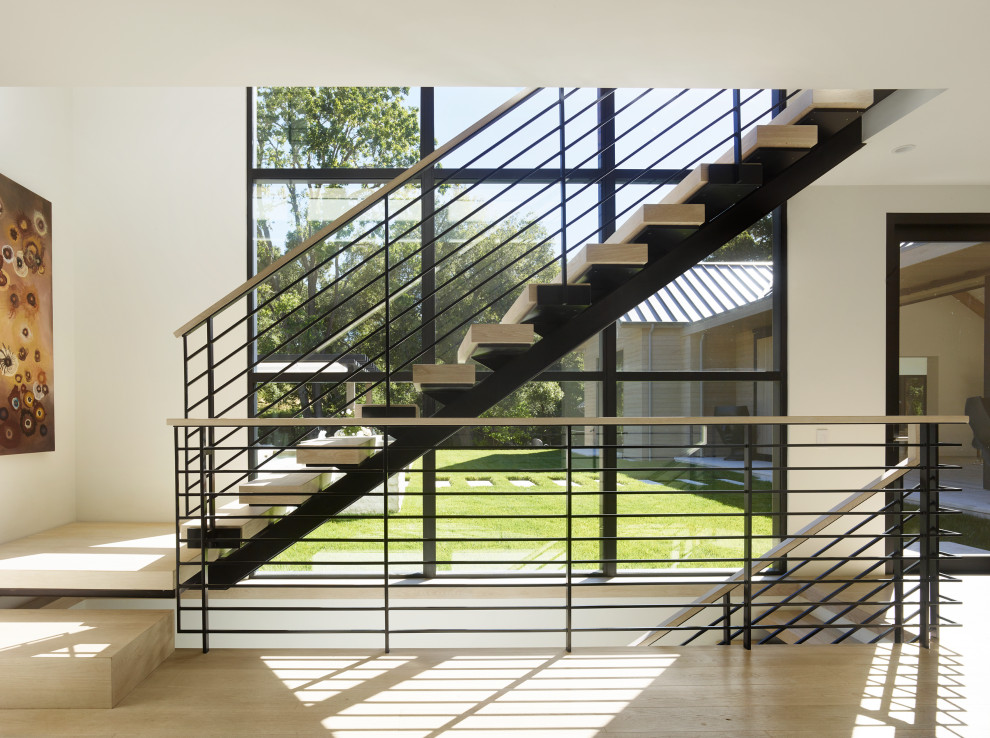 Design ideas for a country wood floating staircase in San Francisco with wood risers and metal railing.