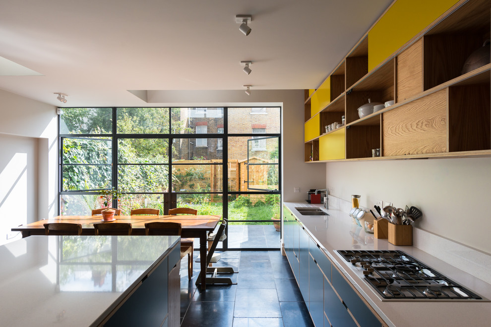 Contemporary eat-in kitchen in London with medium wood cabinets, quartz benchtops, white splashback, stone slab splashback, panelled appliances, slate floors and with island.