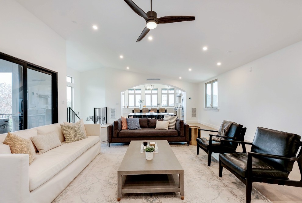 Inspiration for a transitional open concept living room in Austin with white walls, light hardwood floors and beige floor.