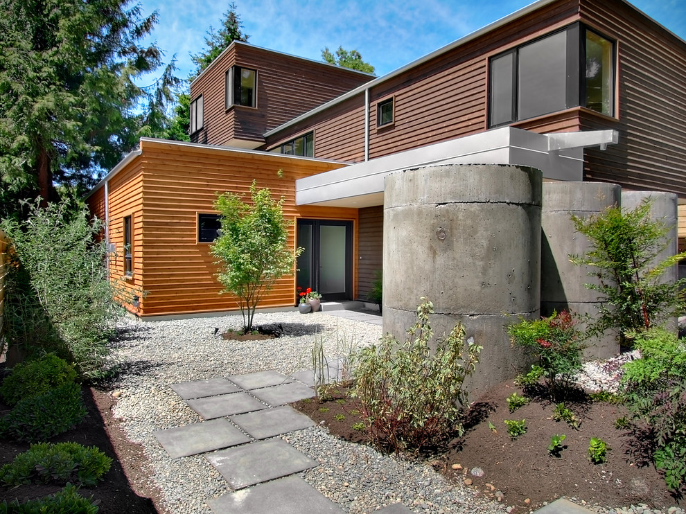 This is an example of a large contemporary three-storey multi-coloured house exterior in Seattle with wood siding and a flat roof.