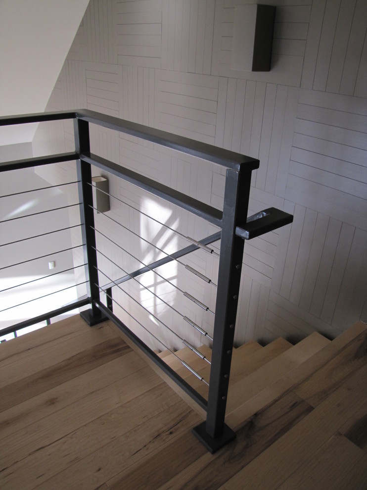 This is an example of a mid-sized modern wood straight staircase in Orange County with open risers.