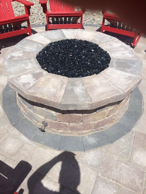Photo of a mid-sized beach style backyard patio in Milwaukee with a fire feature, concrete pavers and no cover.