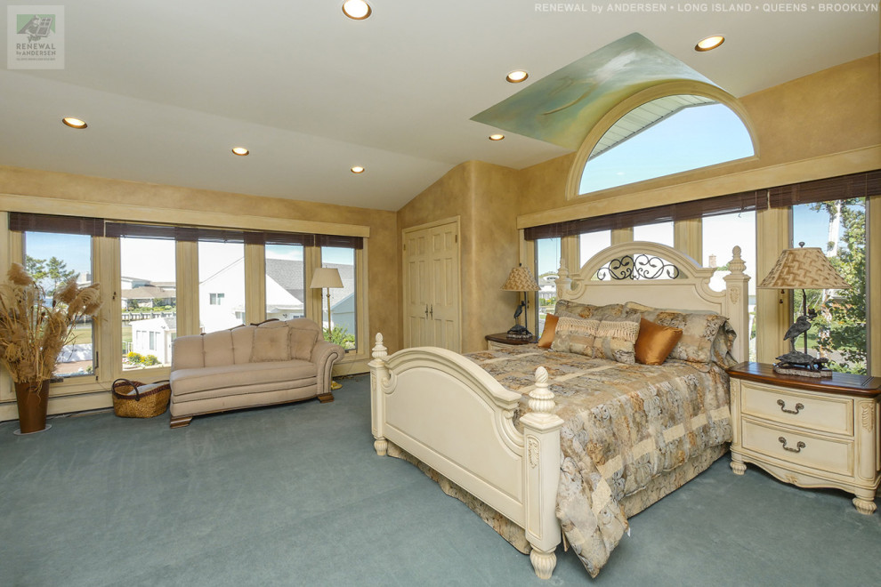Стильный дизайн: большая хозяйская спальня с бежевыми стенами, ковровым покрытием, синим полом и сводчатым потолком без камина - последний тренд