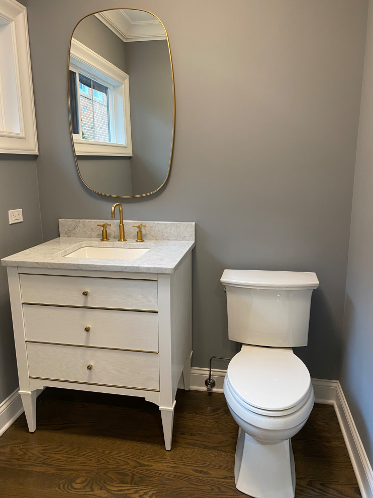 Inspiration for a small cloakroom in Chicago with white cabinets, grey walls, medium hardwood flooring, a built-in sink, brown floors, white worktops, a freestanding vanity unit and panelled walls.