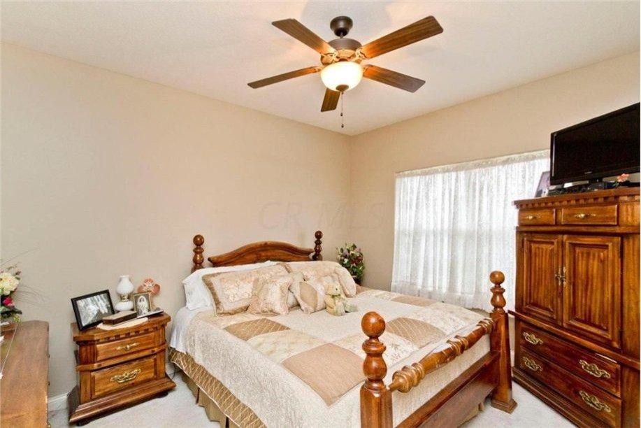 Photo of a large traditional bedroom in Columbus with beige walls, carpet and no fireplace.