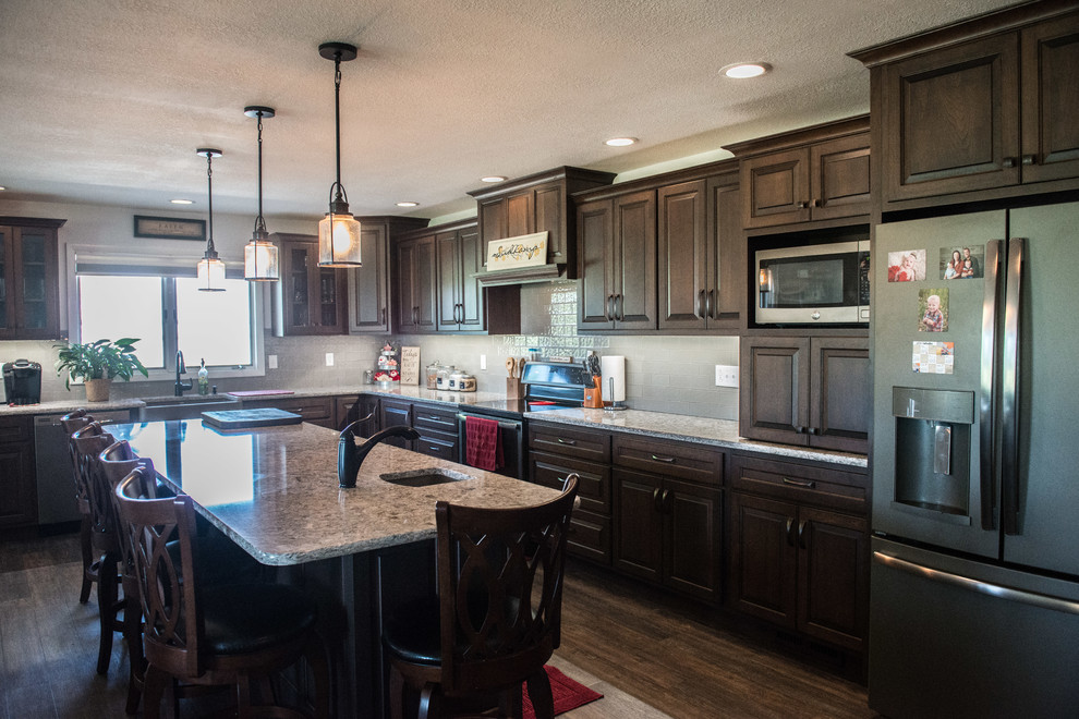 Inspiration for a huge transitional l-shaped medium tone wood floor open concept kitchen remodel with a farmhouse sink, raised-panel cabinets, medium tone wood cabinets, quartz countertops, gray backsplash, subway tile backsplash, stainless steel appliances, an island and multicolored countertops