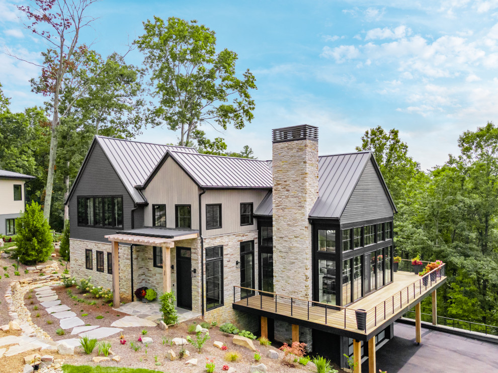 Пример оригинального дизайна: частный загородный дом в стиле модернизм с комбинированной облицовкой и металлической крышей