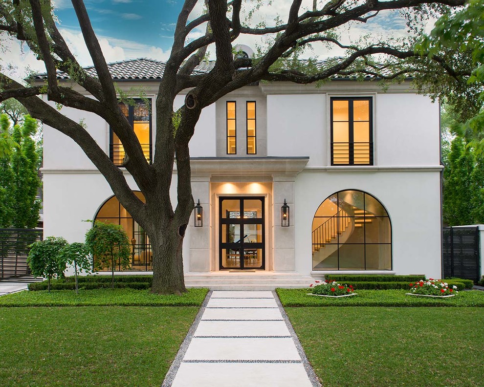 This is an example of a large contemporary two-storey stucco white house exterior in Dallas with a hip roof and a tile roof.