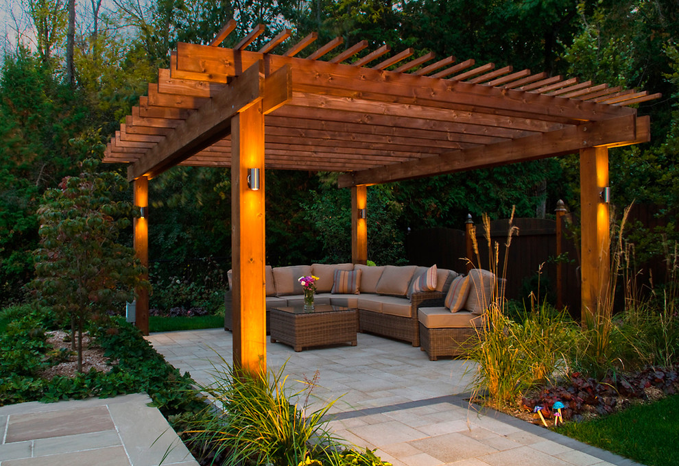 Design ideas for a mid-sized contemporary backyard patio in Toronto with a water feature, natural stone pavers and a pergola.