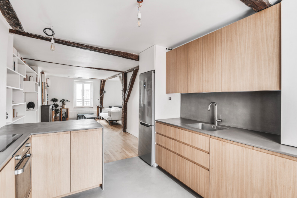 This is an example of an expansive contemporary eat-in kitchen in Paris with a single-bowl sink, concrete benchtops, grey splashback, panelled appliances, concrete floors, multiple islands, grey floor, grey benchtop and exposed beam.
