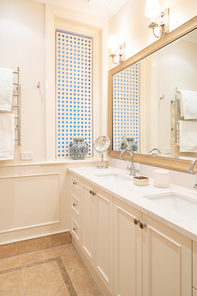 Idées déco pour une salle de bain principale classique de taille moyenne avec des portes de placard beiges, une douche d'angle, un mur beige, un lavabo encastré, un plan de toilette en marbre, un sol beige, une cabine de douche à porte battante, un plan de toilette gris, meuble double vasque et meuble-lavabo encastré.