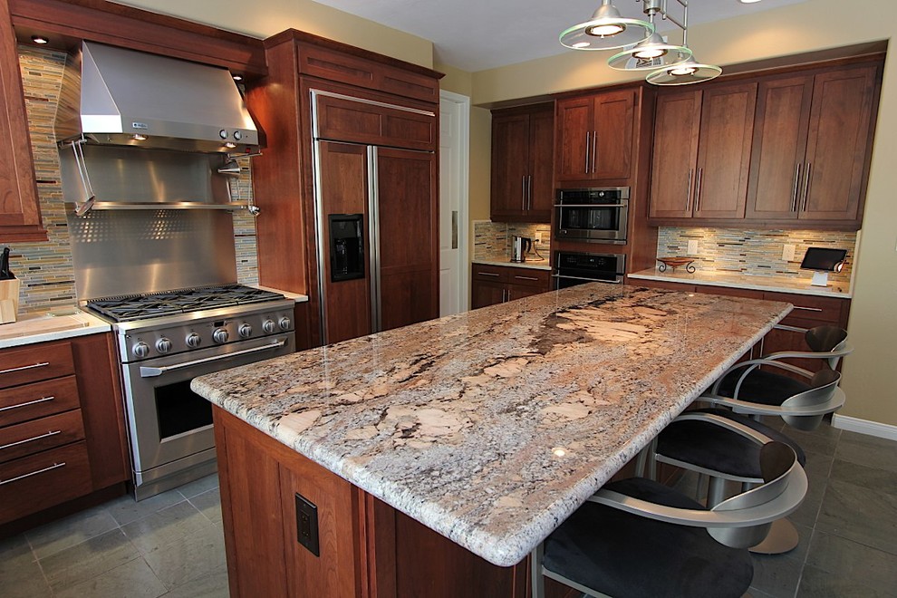 Kitchen - large transitional l-shaped slate floor kitchen idea with an undermount sink, recessed-panel cabinets, medium tone wood cabinets, granite countertops, multicolored backsplash, matchstick tile backsplash, stainless steel appliances and an island