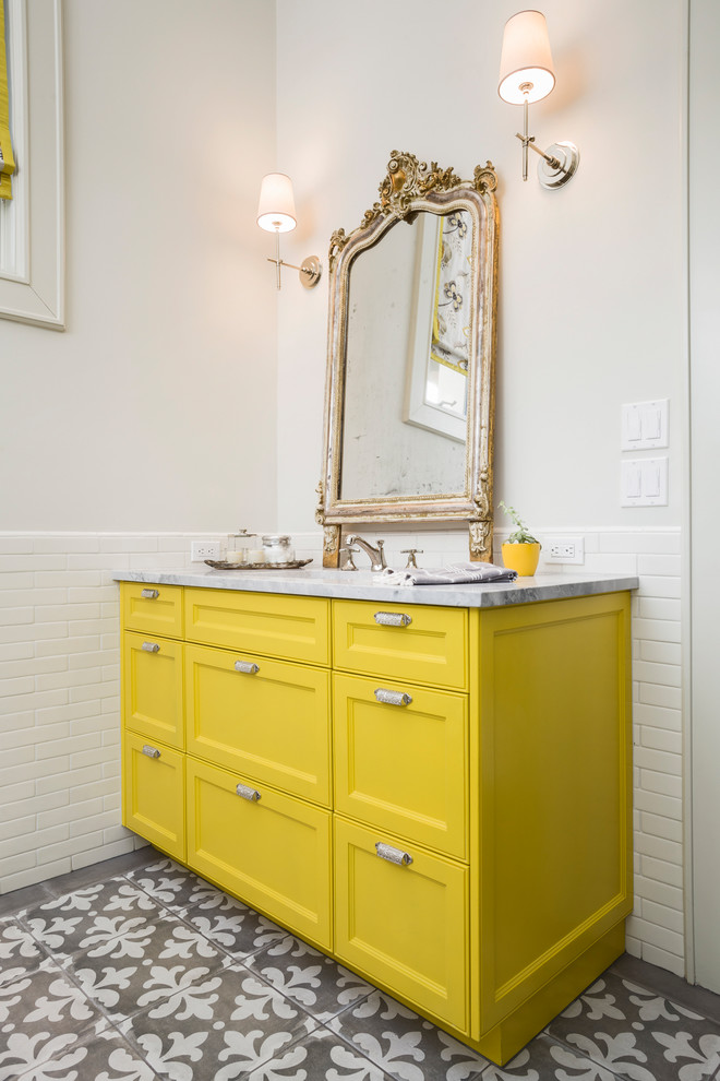 Photo of a mid-sized transitional kids bathroom in Austin with recessed-panel cabinets, yellow cabinets, white tile, ceramic tile, white walls, porcelain floors and granite benchtops.