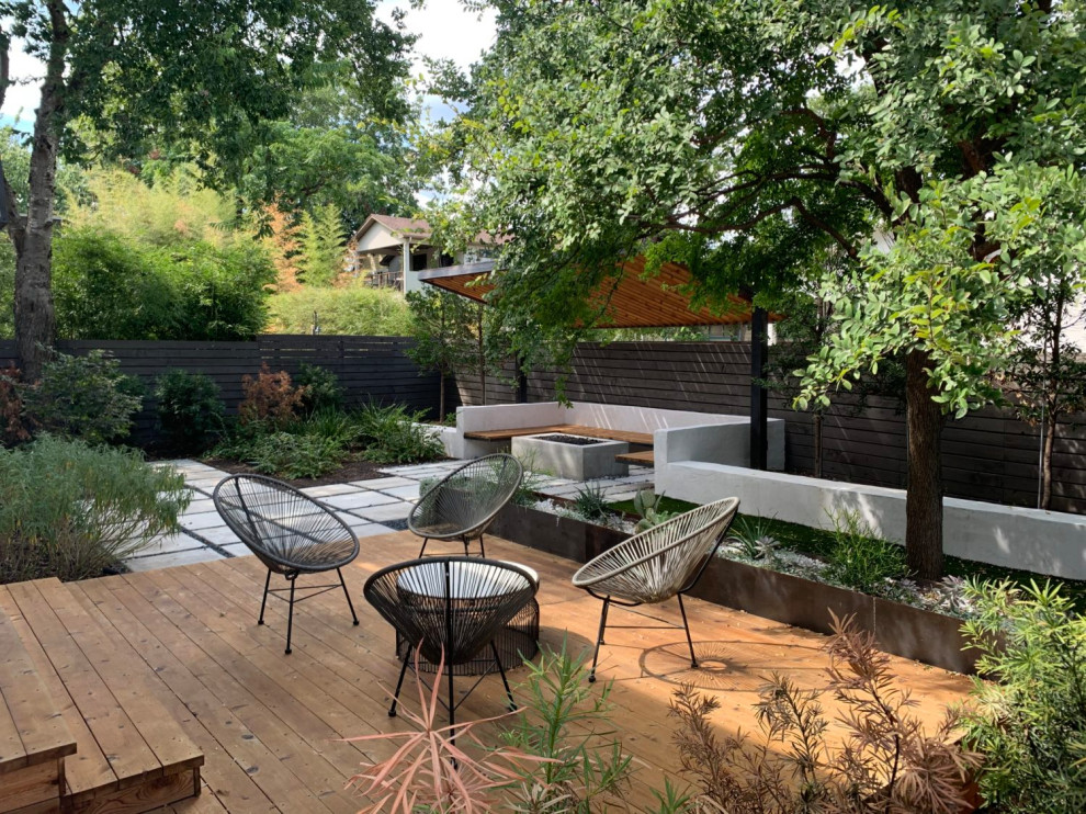 This is an example of a modern backyard full sun garden for summer in Austin with concrete pavers.