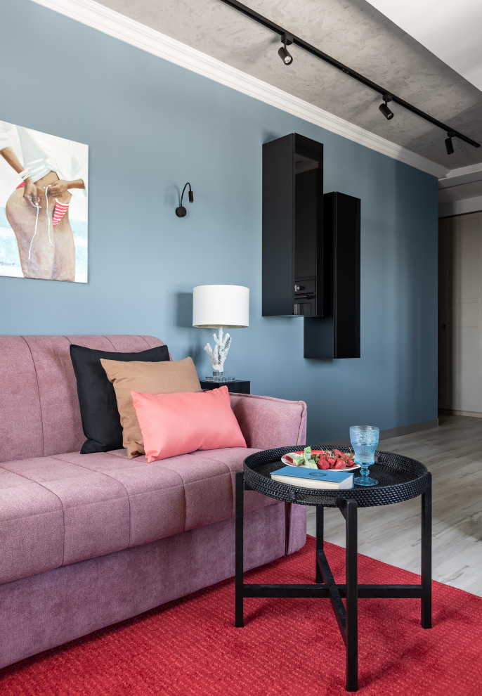 Aménagement d'un petit salon ouvert avec un mur bleu, un sol en carrelage de porcelaine et un sol beige.