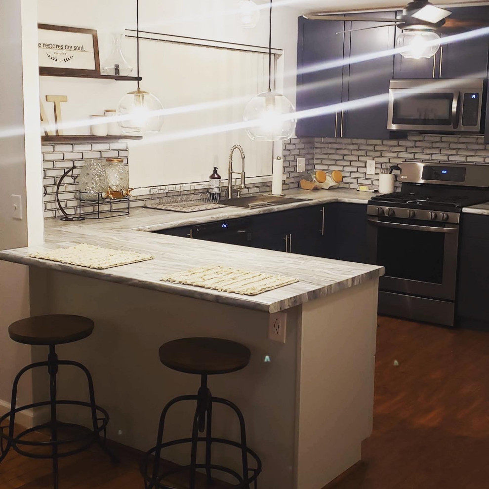 Inspiration for a mid-sized modern u-shaped laminate floor and brown floor eat-in kitchen remodel in St Louis with a single-bowl sink, shaker cabinets, blue cabinets, laminate countertops, gray backsplash, mosaic tile backsplash, stainless steel appliances, a peninsula and gray countertops