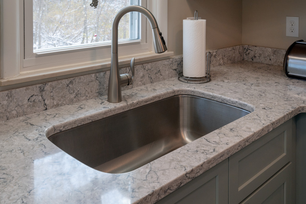 Enclosed kitchen - small transitional l-shaped vinyl floor and brown floor enclosed kitchen idea with an undermount sink, shaker cabinets, green cabinets, quartz countertops, stainless steel appliances, a peninsula and gray countertops