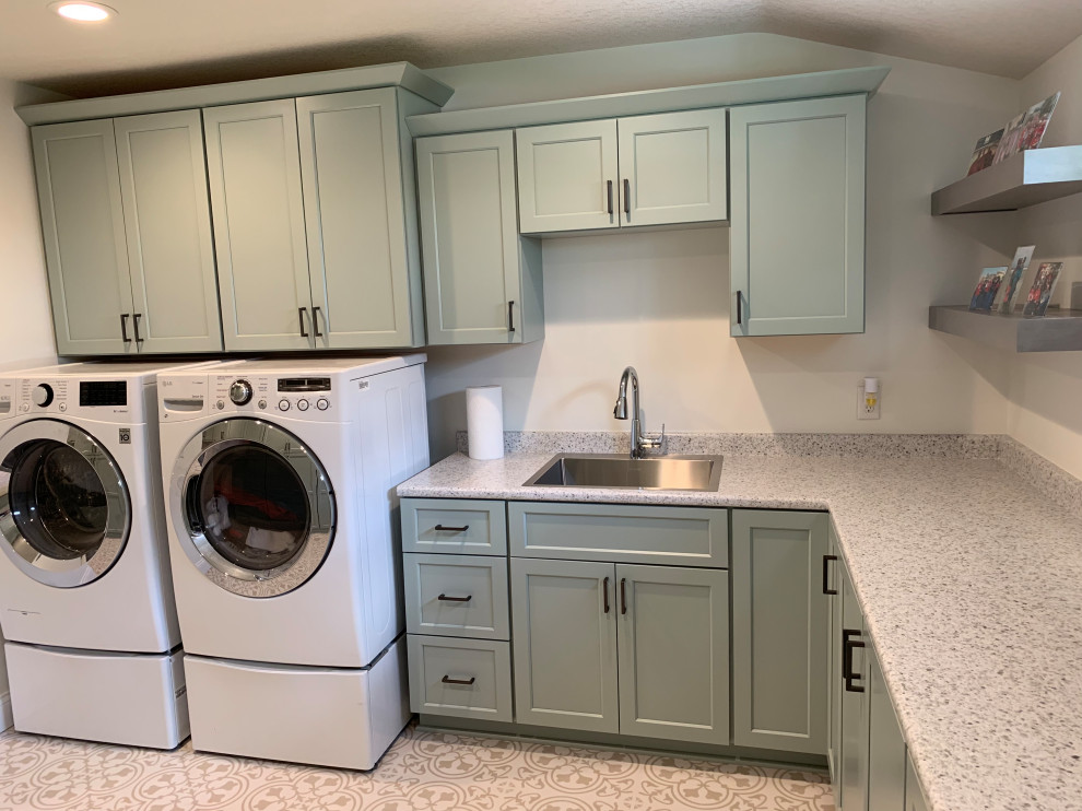 Large elegant u-shaped vinyl floor and white floor utility room photo in Other with a drop-in sink, recessed-panel cabinets, green cabinets, laminate countertops, white walls, a side-by-side washer/dryer and white countertops