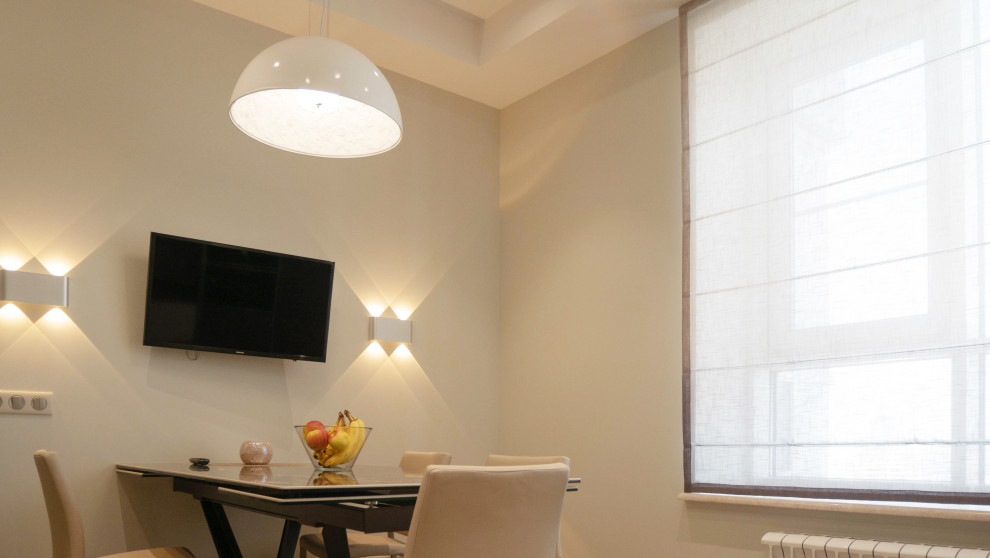 Immagine di una grande sala da pranzo aperta verso la cucina design con pareti beige, pavimento in legno massello medio e soffitto ribassato