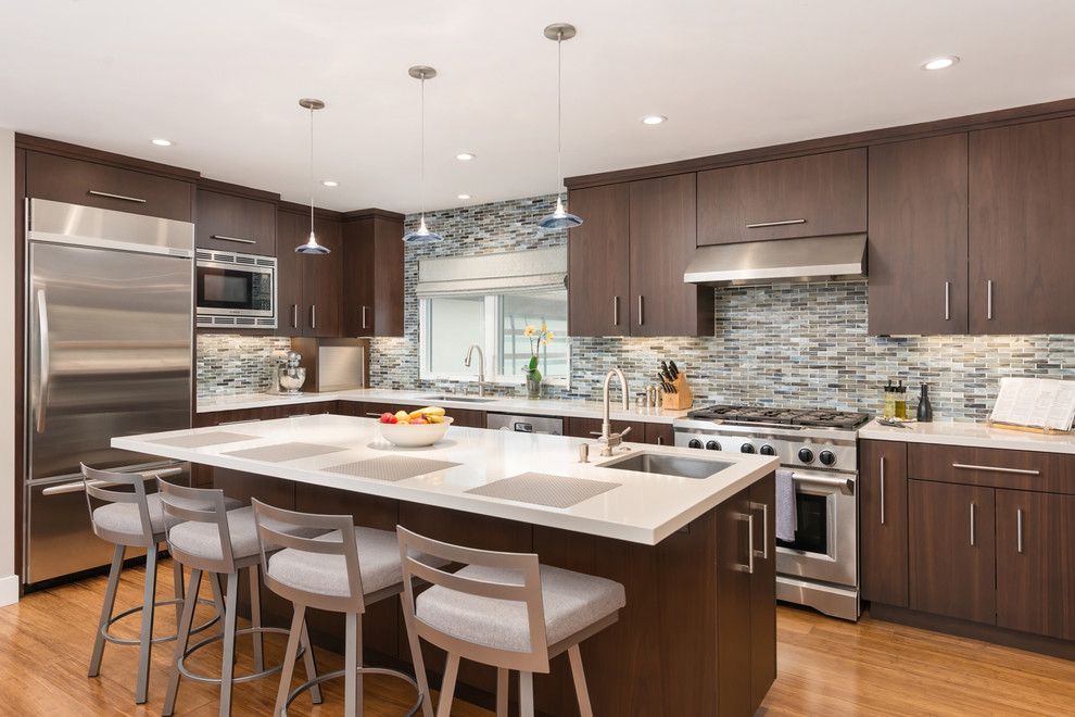 Transitional u-shaped bamboo floor eat-in kitchen photo in San Francisco with an undermount sink, flat-panel cabinets, dark wood cabinets, quartz countertops, gray backsplash, ceramic backsplash, stainless steel appliances and an island