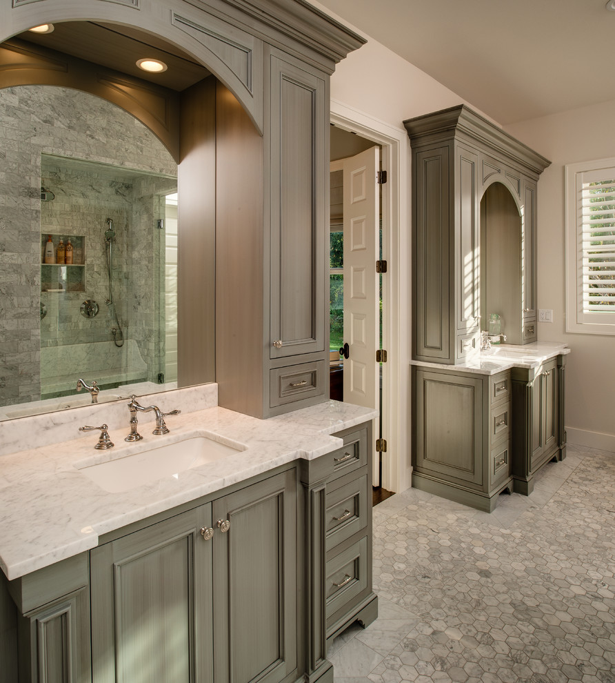 Design ideas for a large beach style master wet room bathroom in Detroit with recessed-panel cabinets, grey cabinets, a freestanding tub, grey walls, marble floors, an undermount sink, marble benchtops, gray tile, marble, grey floor, a hinged shower door and white benchtops.