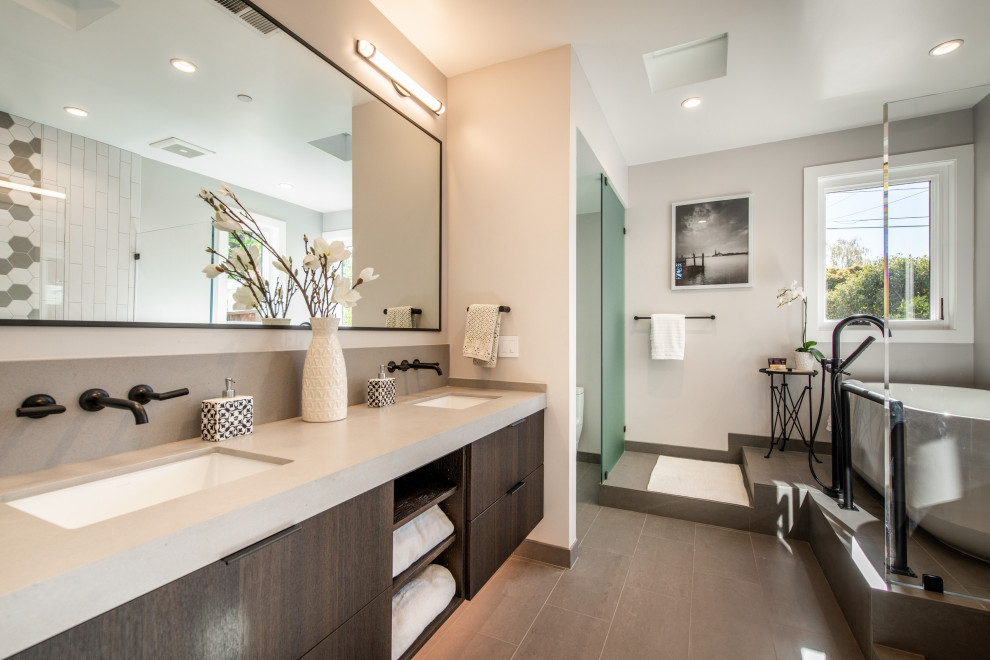 Large modern ensuite bathroom in San Francisco with a freestanding bath, a built-in shower, double sinks, open cabinets, a built-in sink, an open shower, an enclosed toilet and a floating vanity unit.