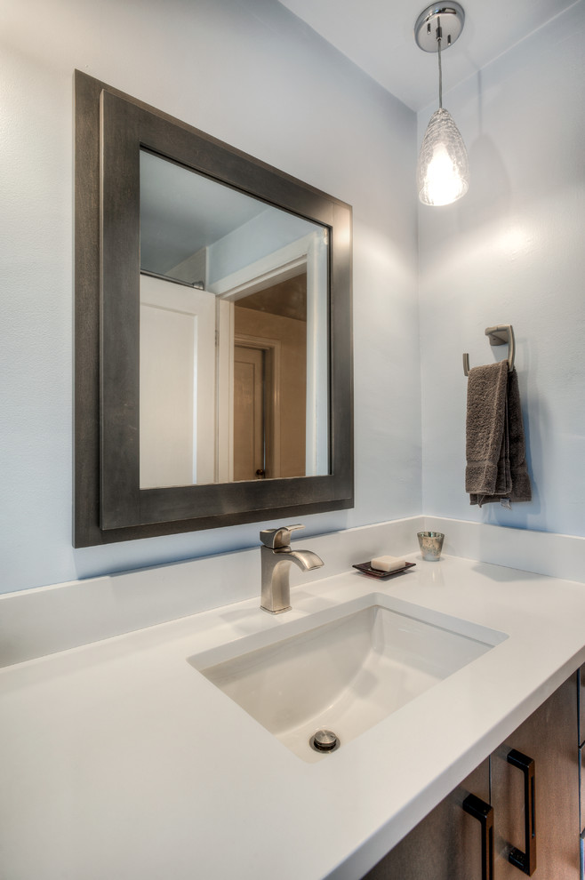 This is an example of a mid-sized transitional master bathroom in Seattle with recessed-panel cabinets, white cabinets, an undermount tub, a shower/bathtub combo, a one-piece toilet, white tile, blue walls, concrete floors, an undermount sink and quartzite benchtops.