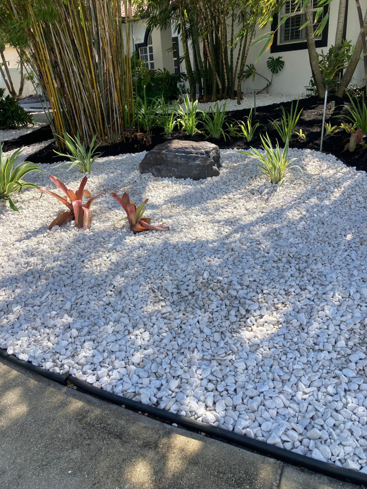 Imagen de jardín de secano tropical extra grande en verano en patio delantero con roca decorativa, exposición total al sol y piedra decorativa