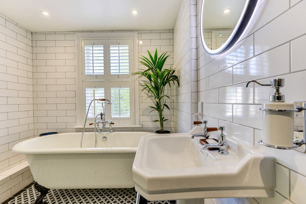 Inspiration for a mid-sized victorian kids' white tile and ceramic tile ceramic tile, multicolored floor and single-sink bathroom remodel in Sussex with a two-piece toilet, white walls, a pedestal sink, tile countertops and black countertops
