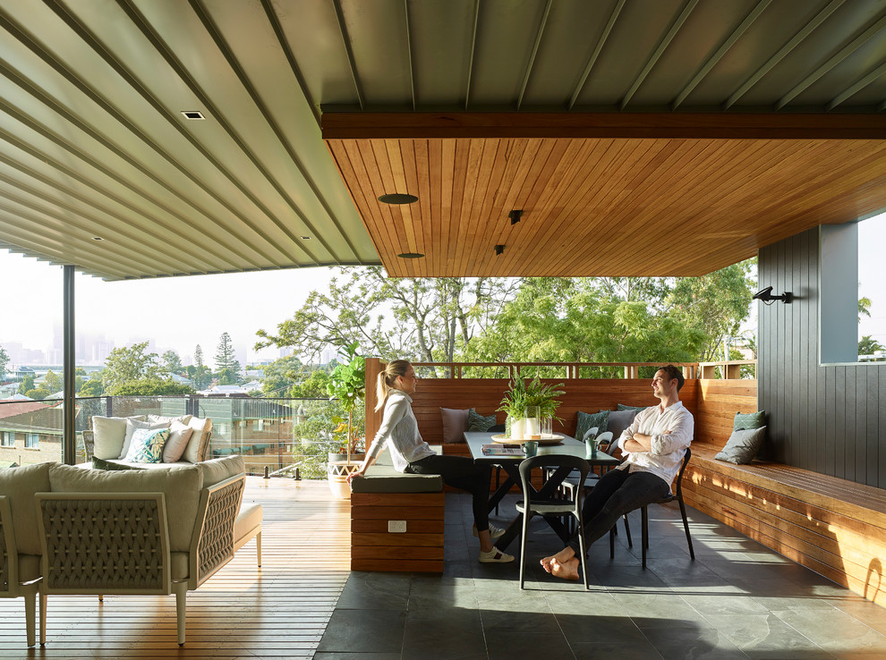 Photo of a contemporary deck in Brisbane with a roof extension.