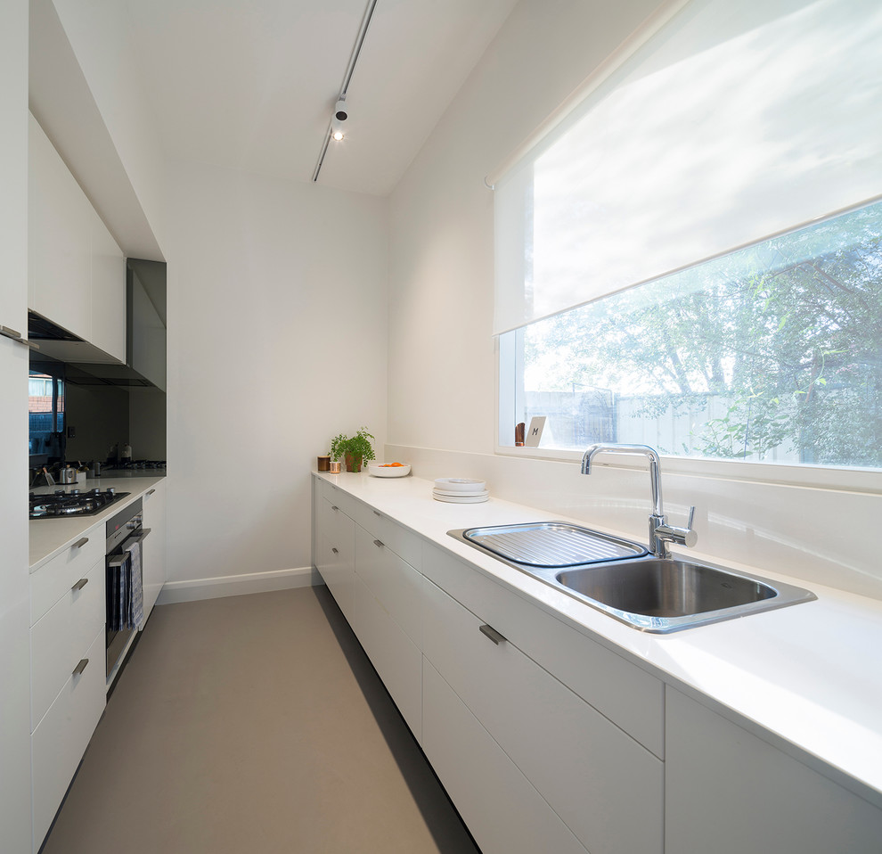 Design ideas for a small scandinavian galley eat-in kitchen in Melbourne with a drop-in sink, white cabinets, quartzite benchtops, black splashback, stainless steel appliances, linoleum floors and no island.