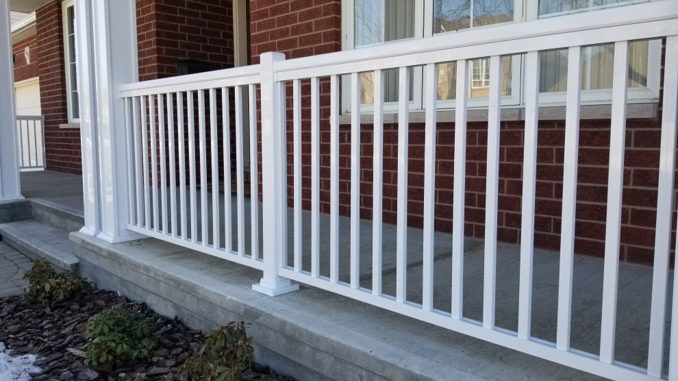 Mid-sized modern front yard verandah in Ottawa with with columns, a roof extension and metal railing.