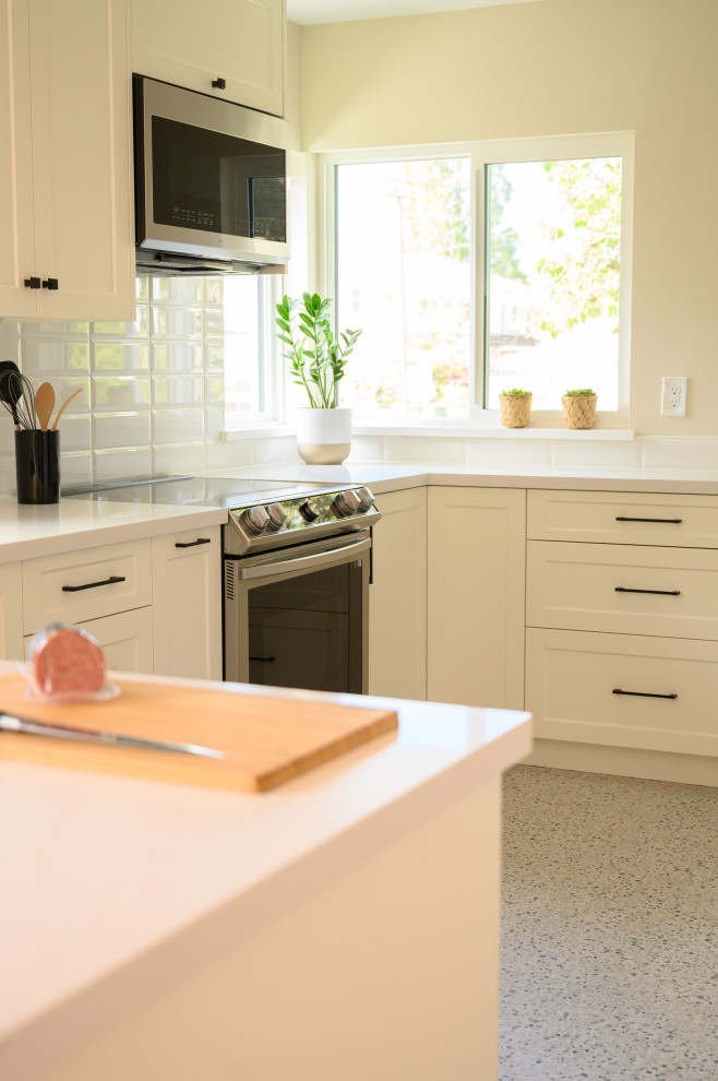 Inspiration for a mid-sized transitional u-shaped eat-in kitchen in Vancouver with a single-bowl sink, recessed-panel cabinets, white cabinets, quartzite benchtops, white splashback, ceramic splashback, stainless steel appliances, terrazzo floors, a peninsula, grey floor and white benchtop.