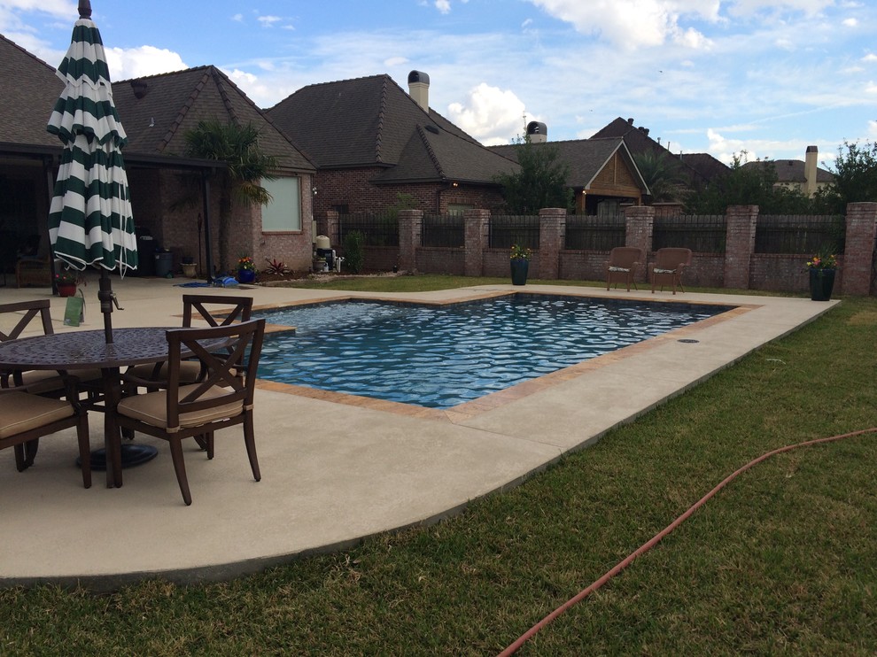Photo of a mid-sized contemporary backyard rectangular pool in New Orleans with a water feature and decking.