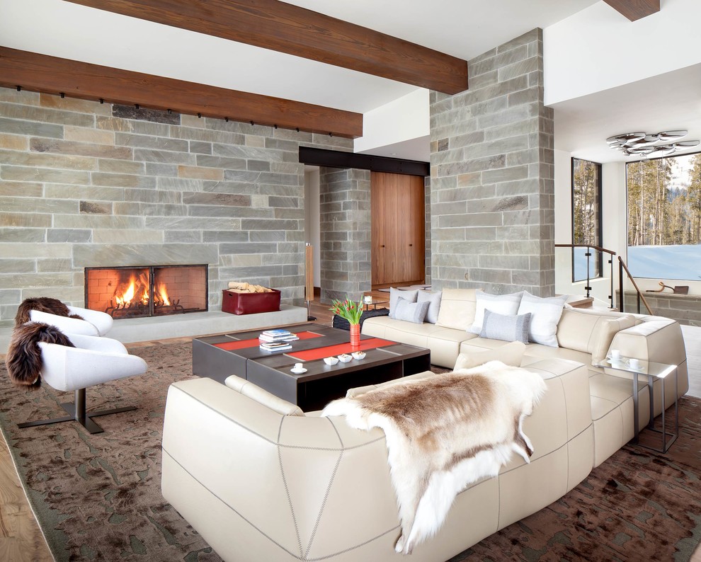 Trendy open concept medium tone wood floor and brown floor living room photo with white walls, a standard fireplace and no tv