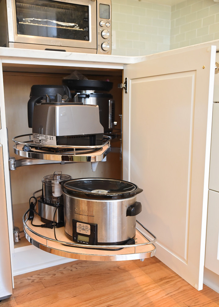 Inspiration for a mid-sized transitional u-shaped medium tone wood floor and brown floor eat-in kitchen remodel with an undermount sink, flat-panel cabinets, white cabinets, quartz countertops, blue backsplash, ceramic backsplash, stainless steel appliances, an island and white countertops