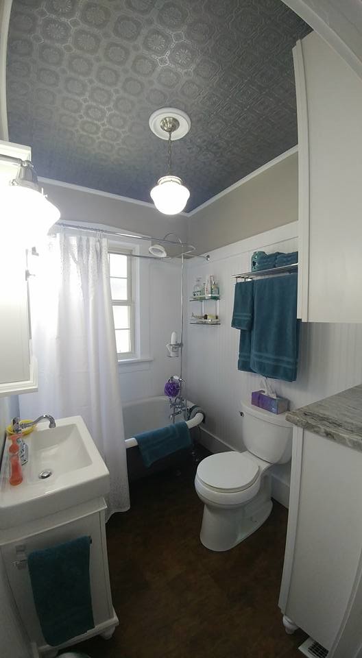 Photo of a small arts and crafts master bathroom in Denver with shaker cabinets, white cabinets, a claw-foot tub, a shower/bathtub combo, a two-piece toilet, white walls, vinyl floors, a console sink, granite benchtops, brown floor and a shower curtain.