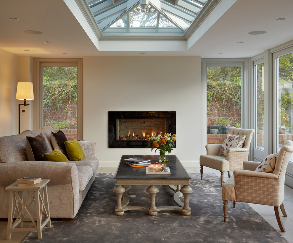 Design ideas for a traditional sunroom in Essex with a skylight, a ribbon fireplace and a stone fireplace surround.