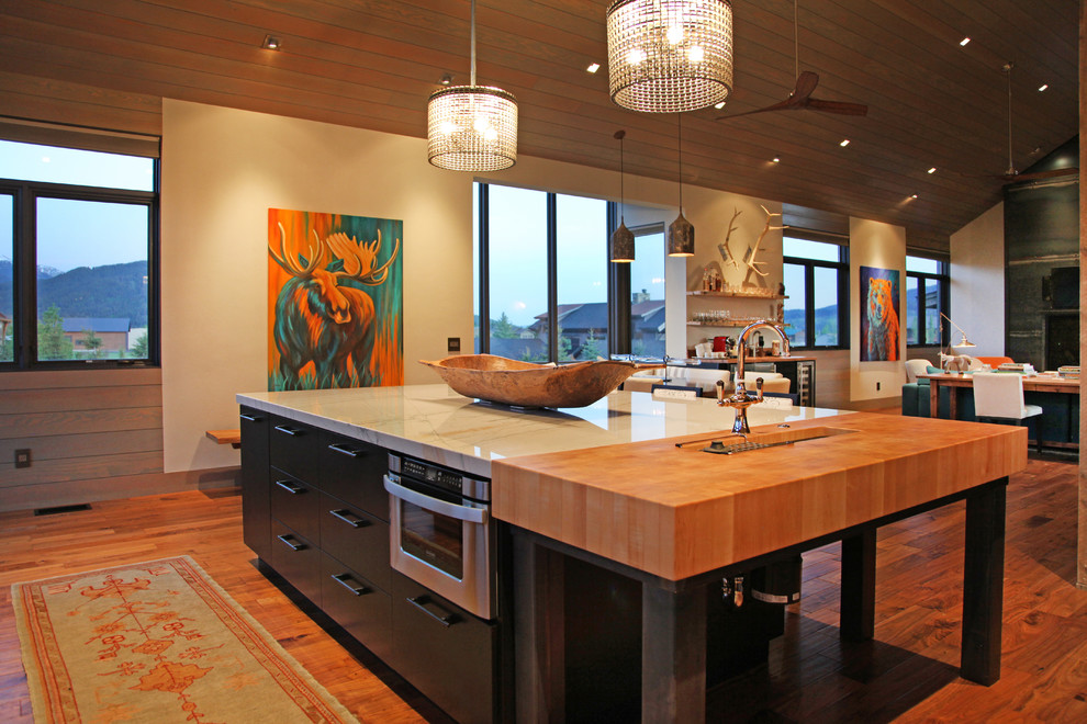 Open concept kitchen - mid-sized contemporary l-shaped medium tone wood floor open concept kitchen idea with a drop-in sink, flat-panel cabinets, stainless steel cabinets, quartzite countertops, stainless steel appliances and an island