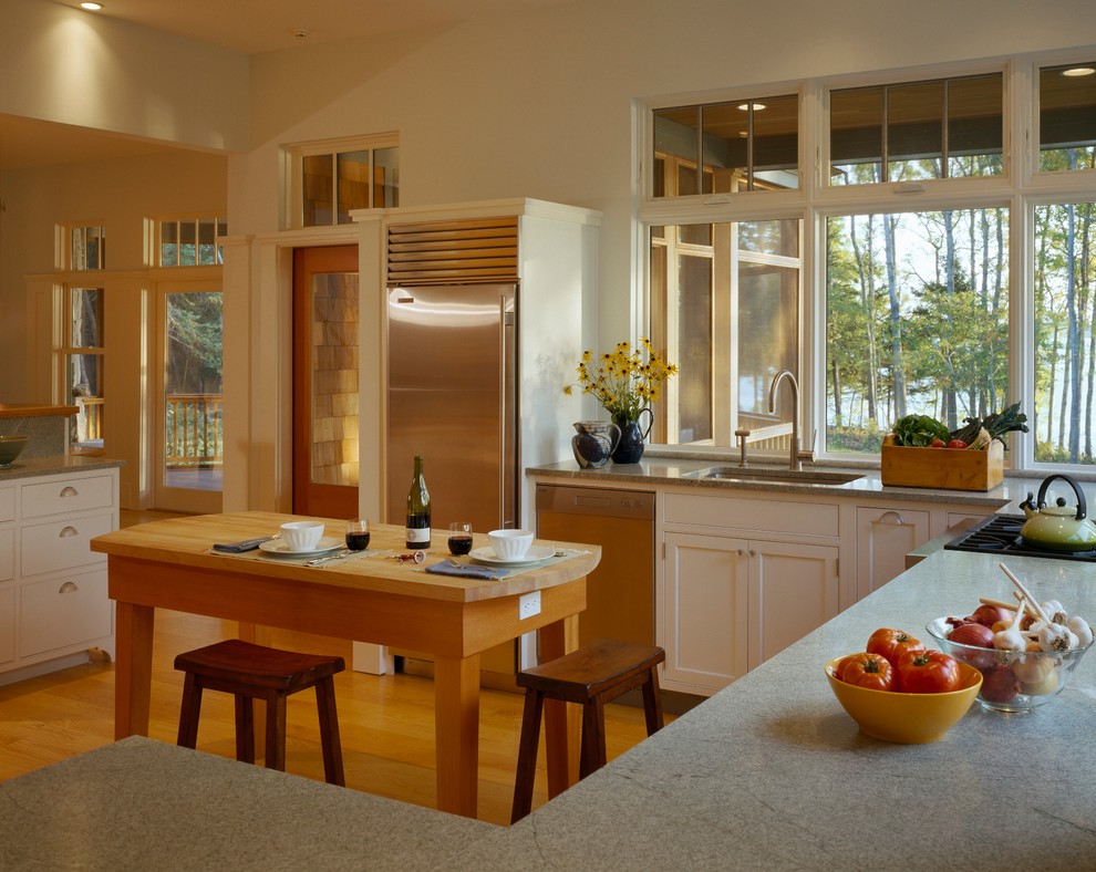 Large transitional u-shaped light wood floor kitchen photo with an undermount sink, shaker cabinets, white cabinets, granite countertops, stainless steel appliances and white walls