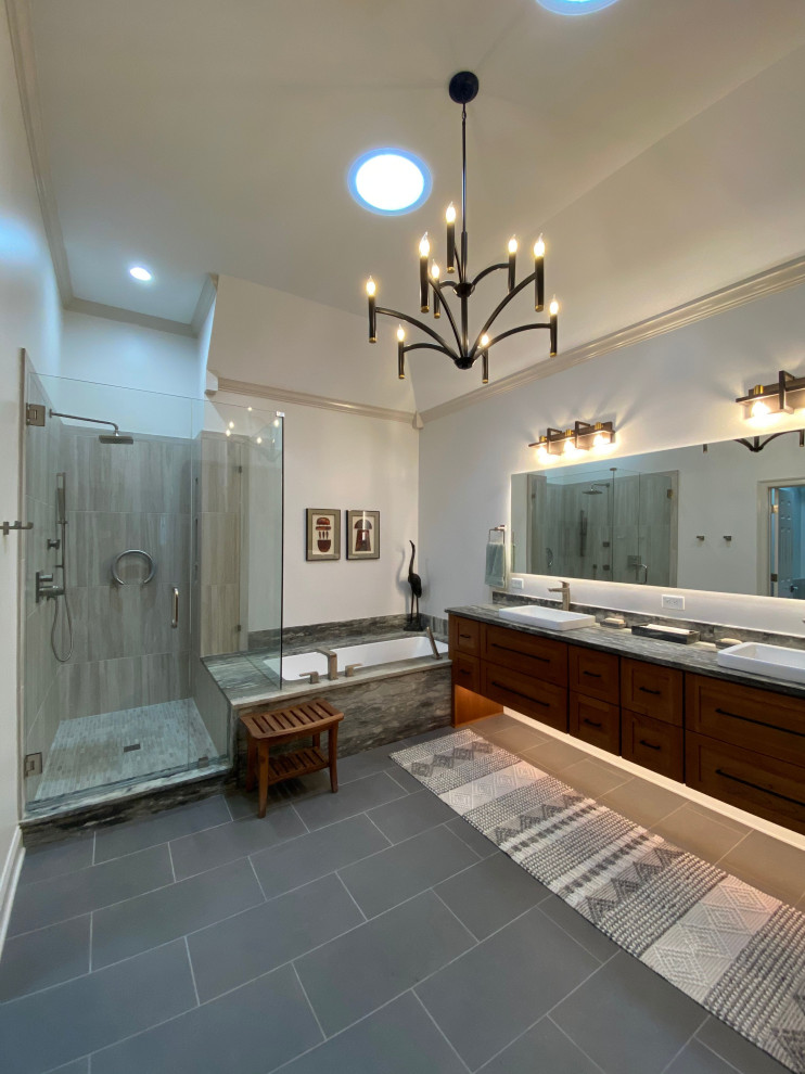 This is an example of a large transitional master bathroom in Other with recessed-panel cabinets, light wood cabinets, an undermount tub, an alcove shower, a bidet, gray tile, porcelain tile, porcelain floors, a vessel sink, granite benchtops, a hinged shower door, grey benchtops, a double vanity and a floating vanity.