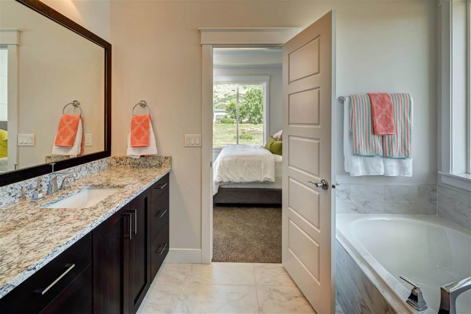 Mid-sized contemporary master bathroom in Salt Lake City with dark wood cabinets, a drop-in tub, black and white tile, granite benchtops, shaker cabinets, beige walls, marble floors, an undermount sink and white floor.