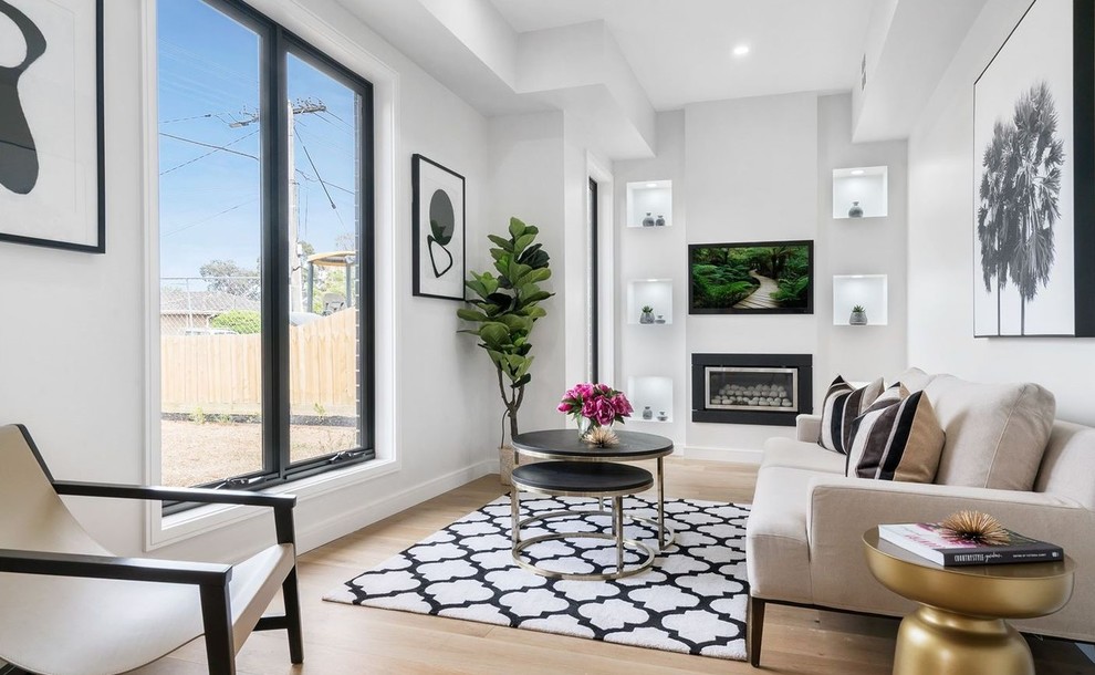 Inspiration for a small contemporary formal enclosed living room in Melbourne with white walls, light hardwood floors, a standard fireplace, a metal fireplace surround, no tv, beige floor and decorative wall panelling.