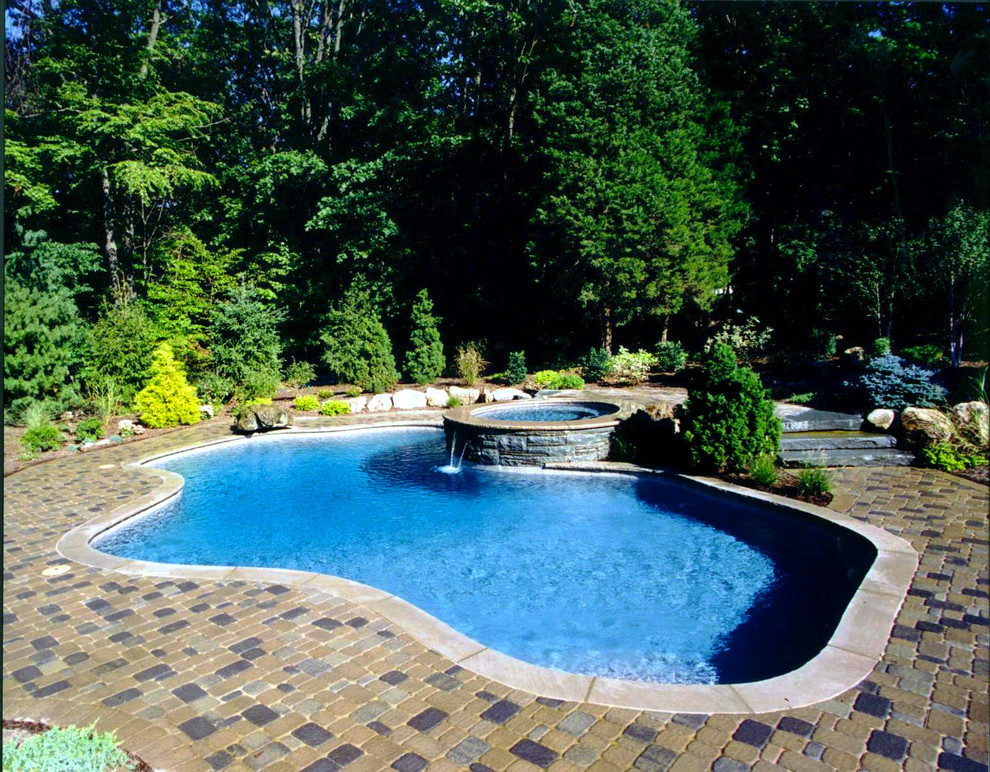 Inspiration for a mid-sized traditional backyard rectangular lap pool in New York with concrete pavers.