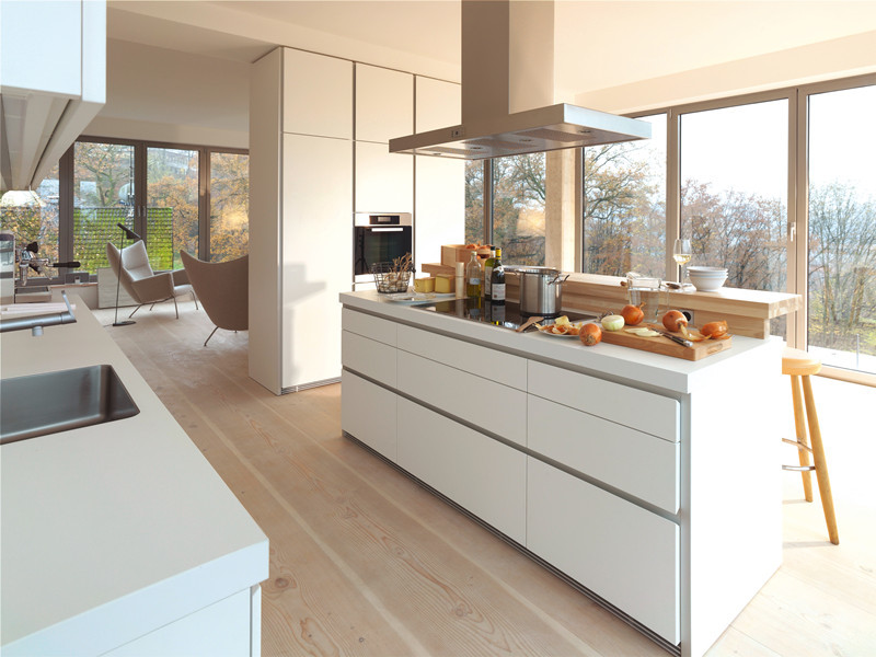 This is an example of a mid-sized modern galley eat-in kitchen in Other with a double-bowl sink, open cabinets, white cabinets, quartzite benchtops, white splashback, cement tile splashback, stainless steel appliances, with island and light hardwood floors.