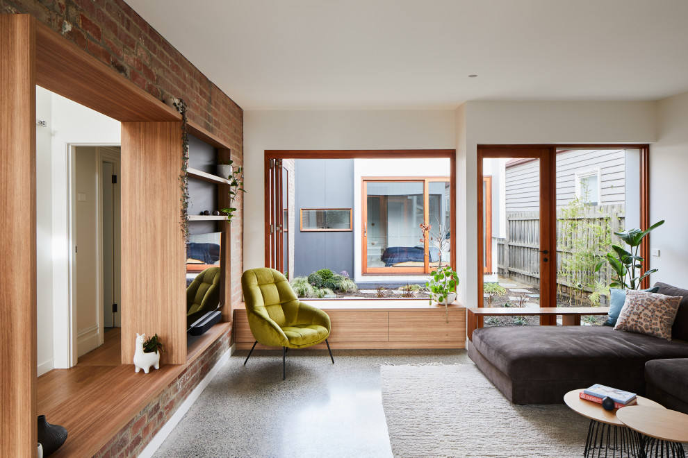 This is an example of a contemporary living room in Melbourne with white walls, concrete floors and grey floor.