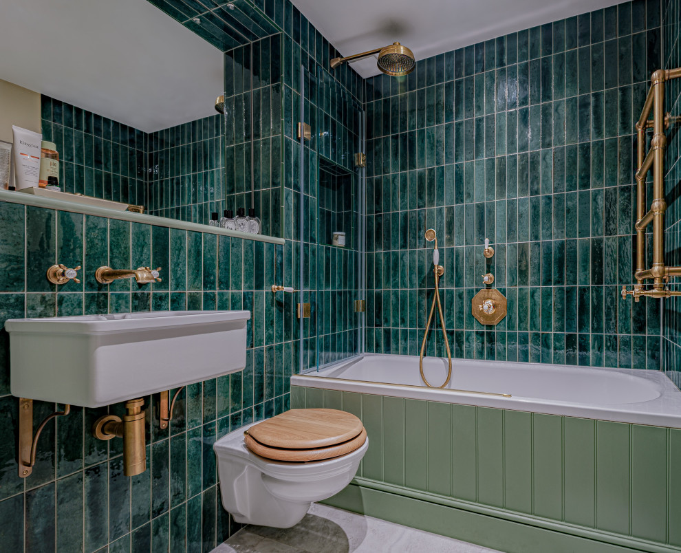 Mid-sized traditional bathroom in London with an alcove tub, a shower/bathtub combo, a wall-mount toilet, green tile, ceramic tile, white walls, porcelain floors, a wall-mount sink, grey floor, a single vanity and panelled walls.